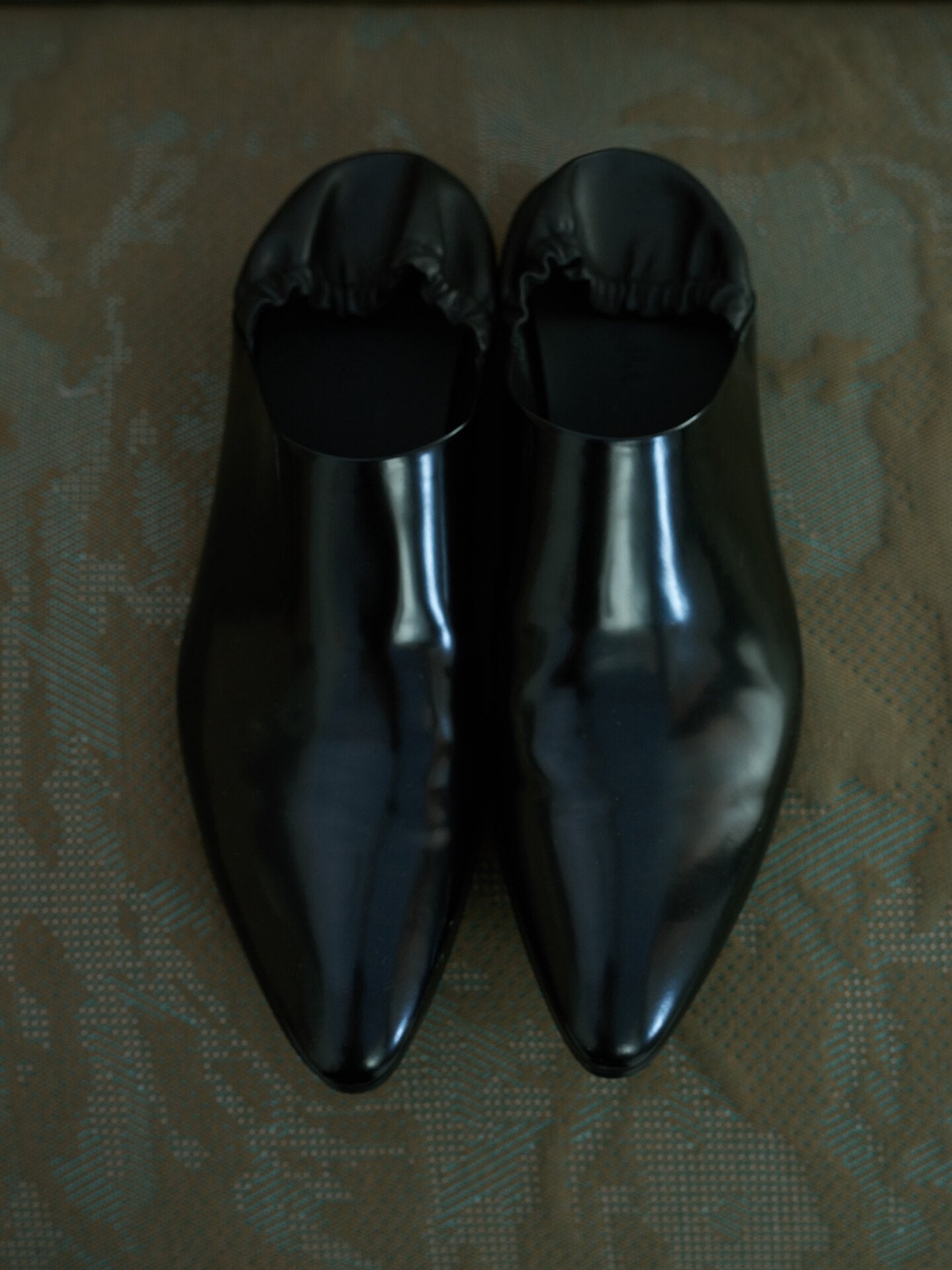 Split‑edge cowhide pointed‑toe black mirror mules