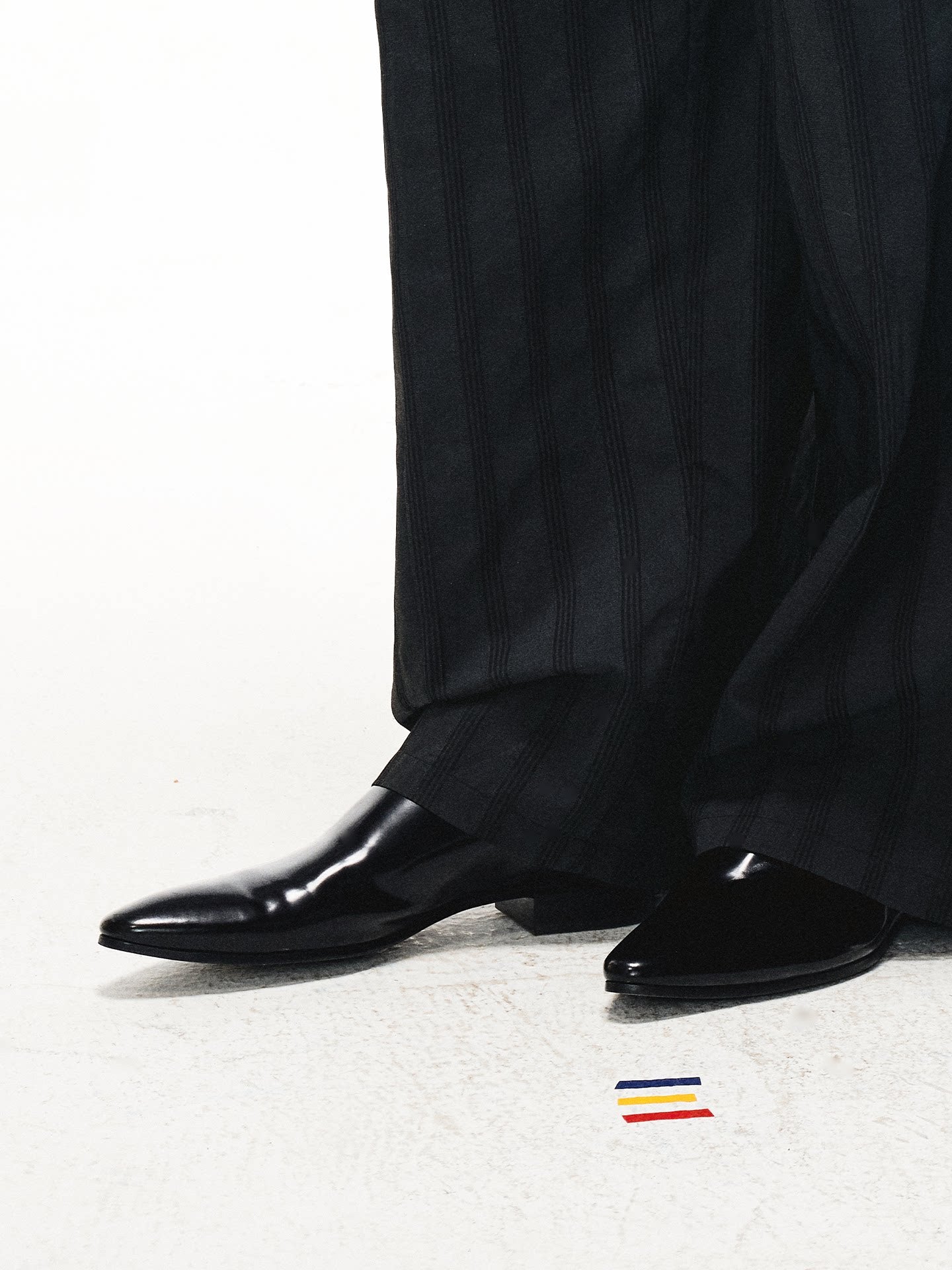 Split‑edge cowhide pointed‑toe black mirror mules